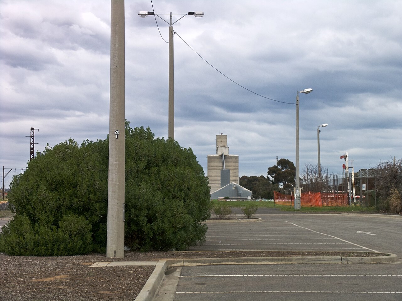 Quiet car park with grain silos in the distance