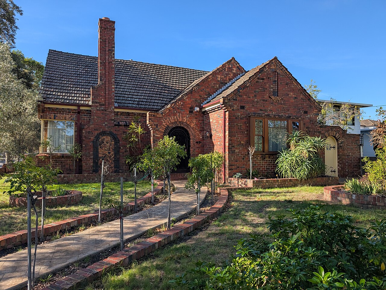 Decorative brick interwar house with a front garden