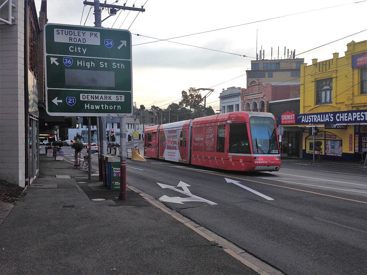Eastern approach to Kew Junction with a tram and shops