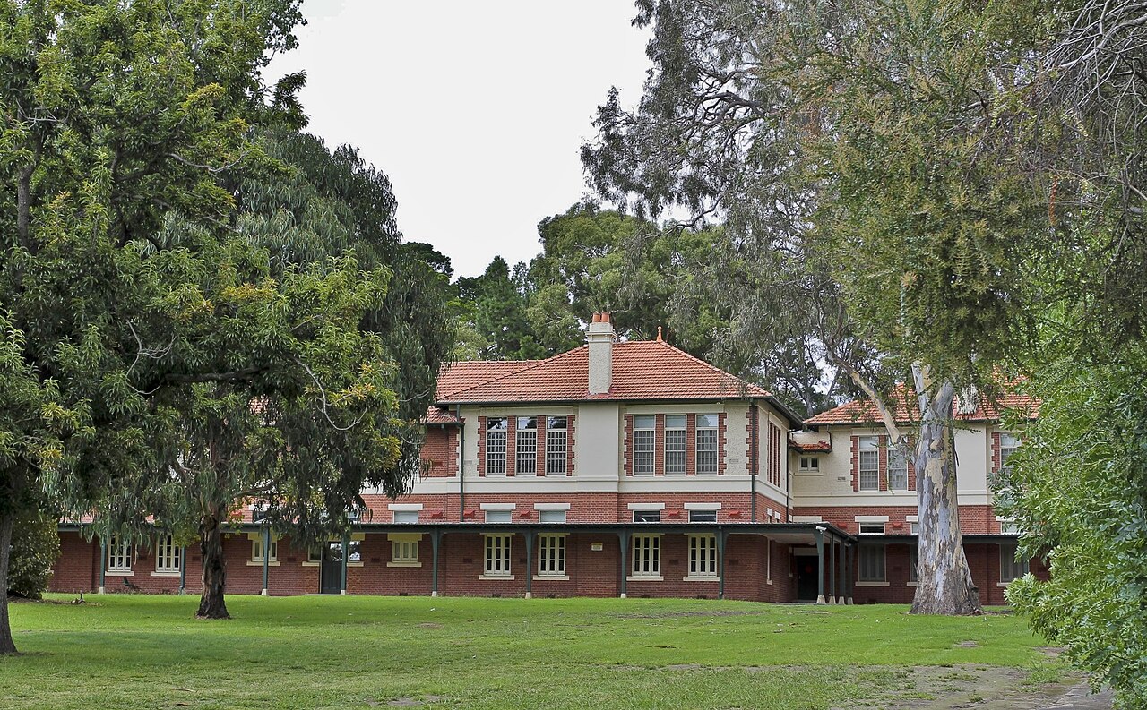 Brick building of the former Mont Park Asylum behind lawns