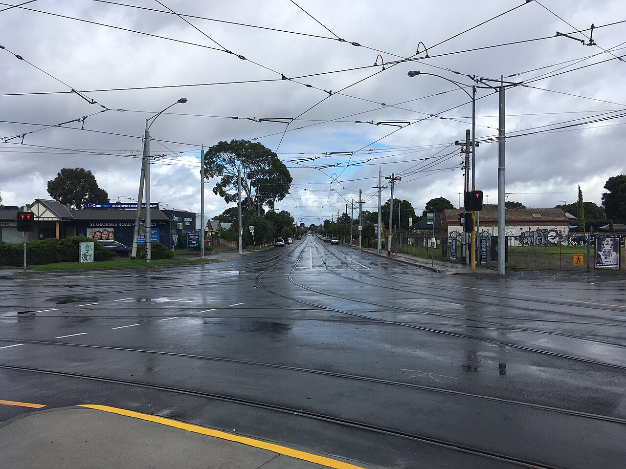 Wet intersection of Miller Street and St Georges Road with tram wires