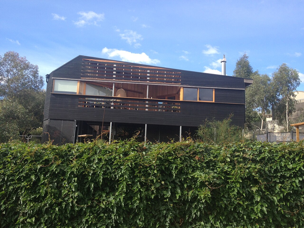 Modern timber house behind a hedge, Ivanhoe