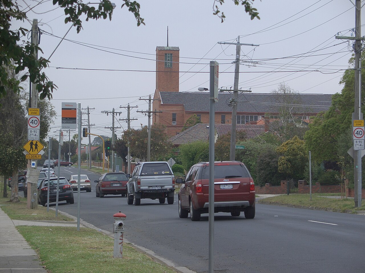Jasper Road with traffic and a church tower