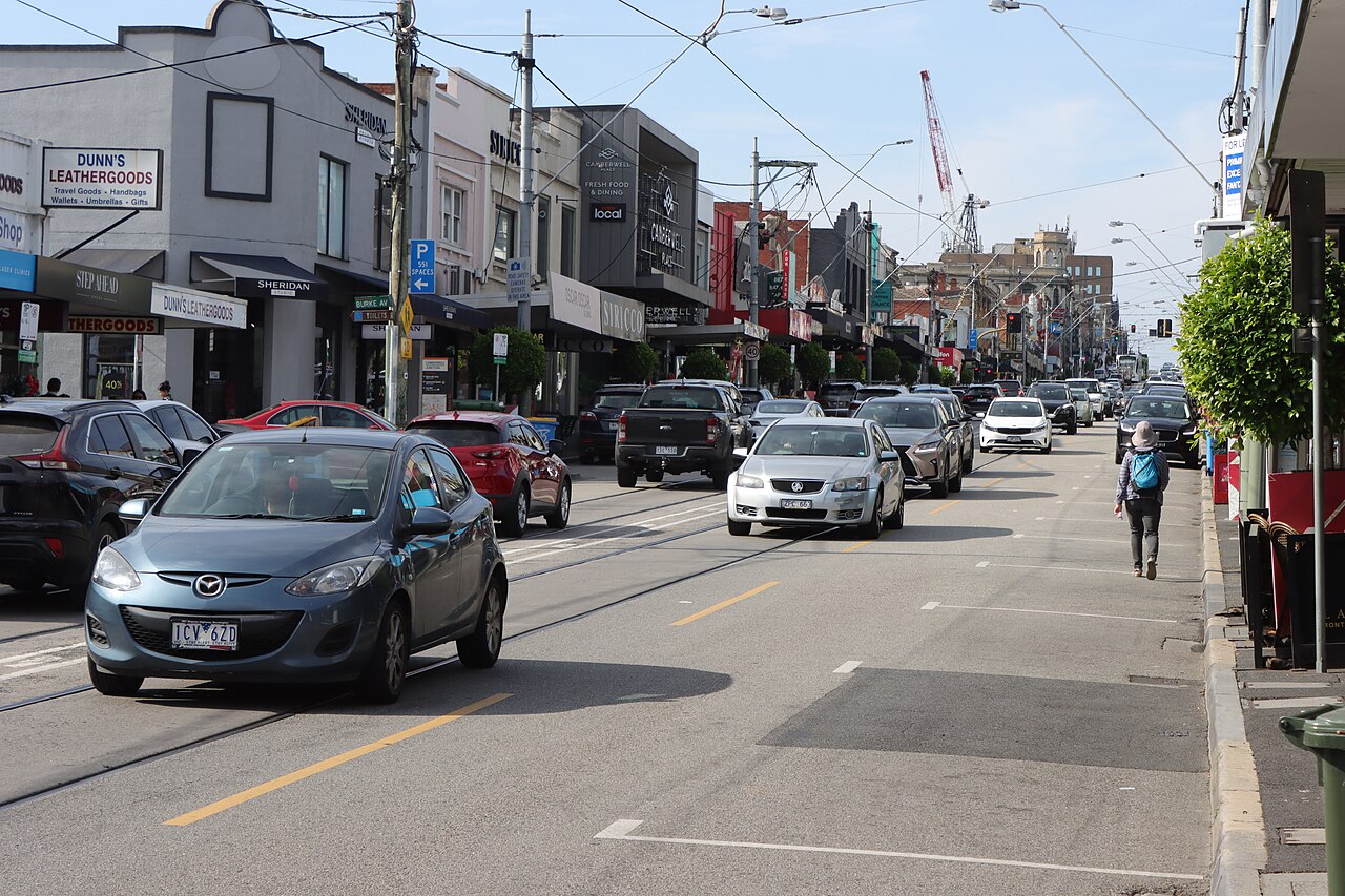 Looking north along Burke Road past shopfronts and traffic