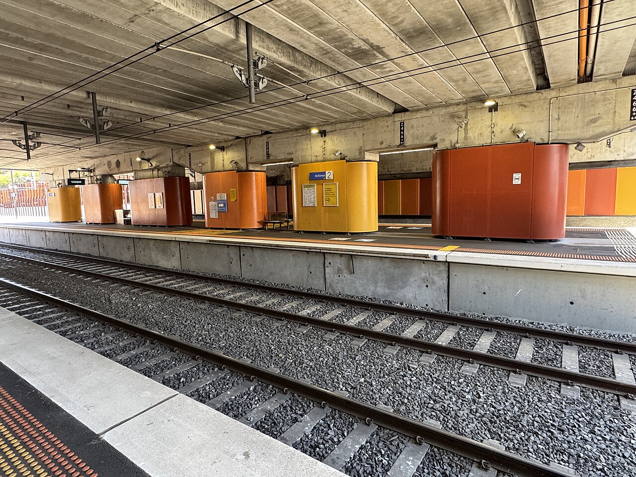Colourful orange and red structures along the platform at McKinnon station