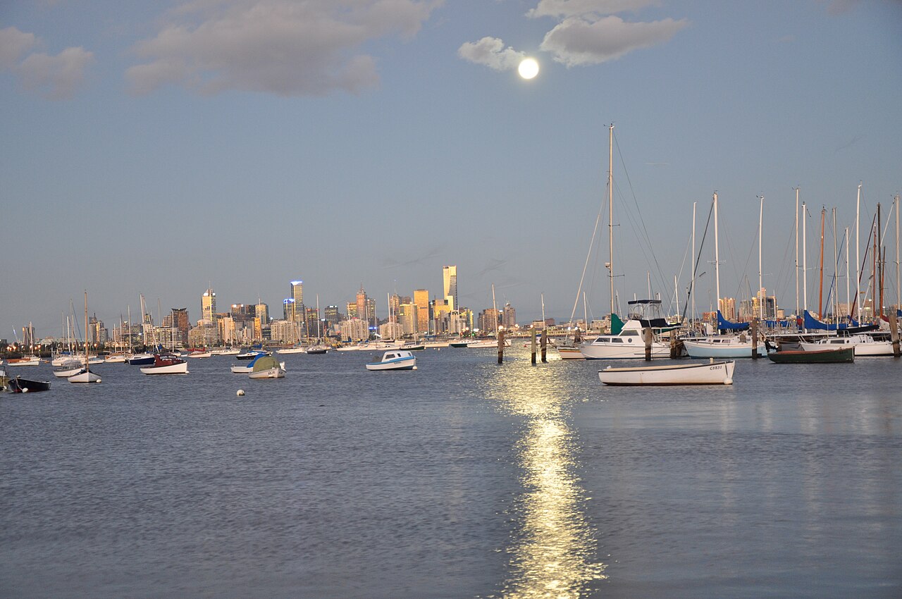 Moonlight over yachts with the Melbourne CBD skyline across the bay from Williamstown