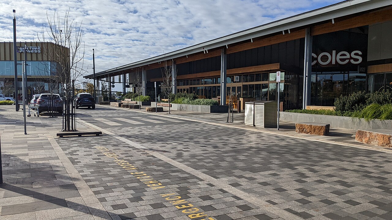 Paved plaza with zebra crossing outside a supermarket