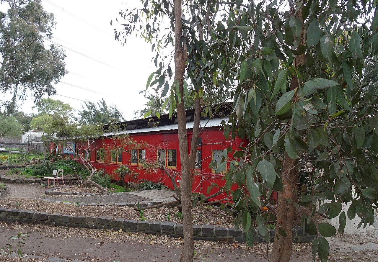 Retired red rail carriage among trees