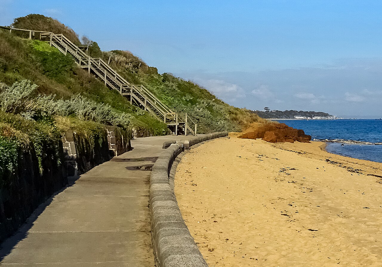 Seawall path and stairs beside the sandy beach at Sandringham