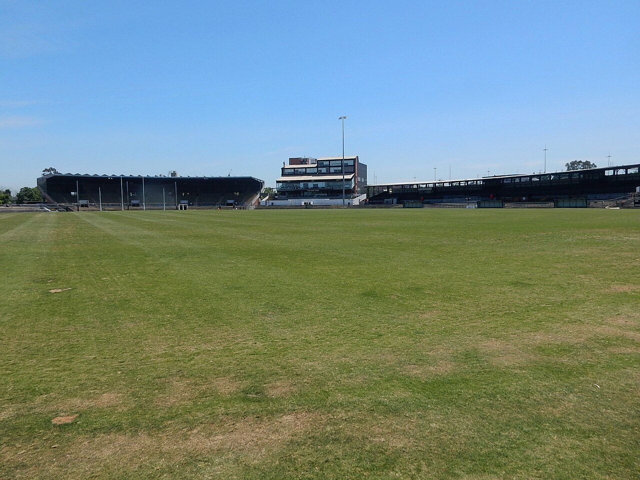 The grass oval of Victoria Park under a blue sky