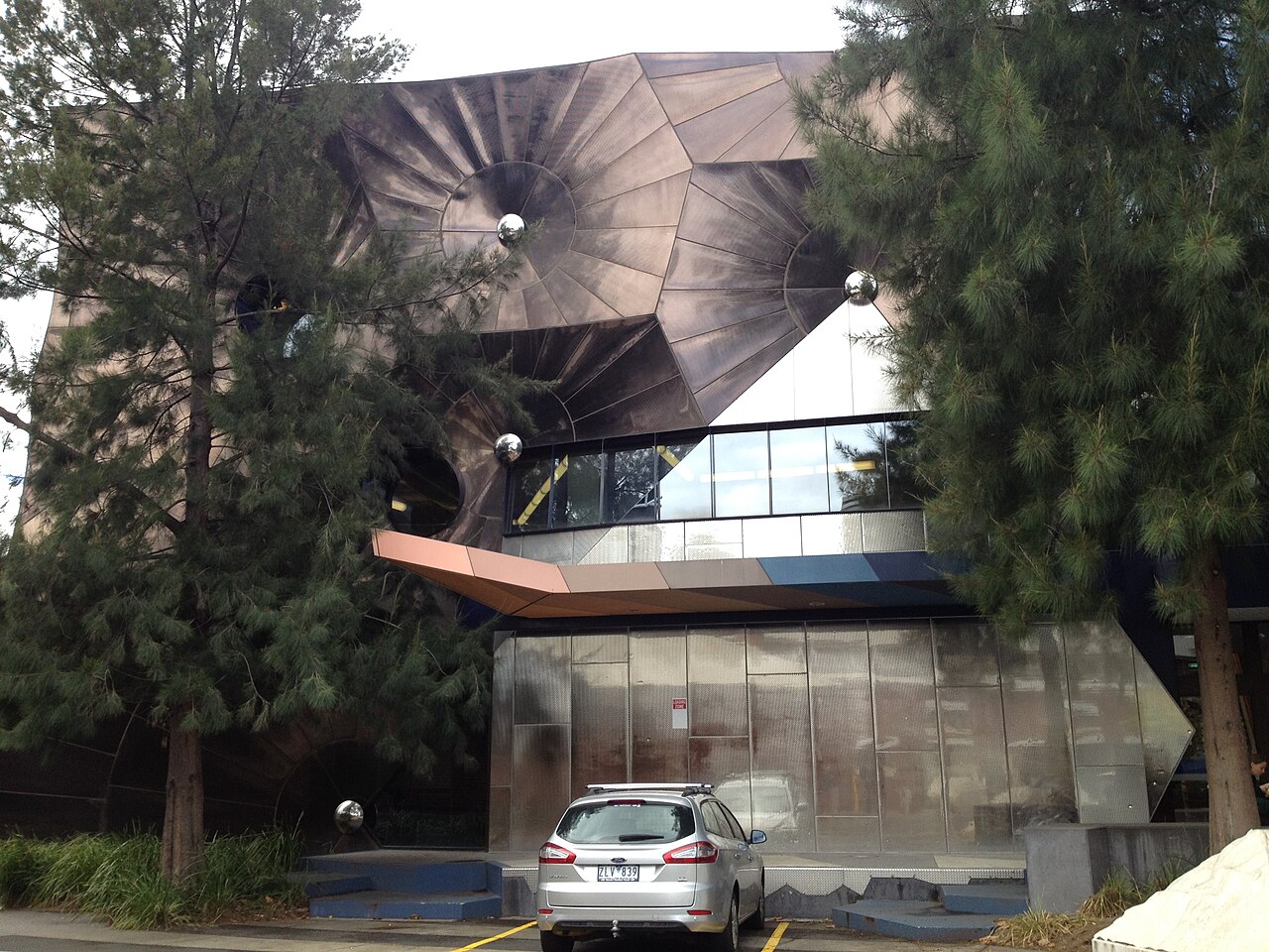 Angular metal-clad building of the Victorian College of the Arts among trees