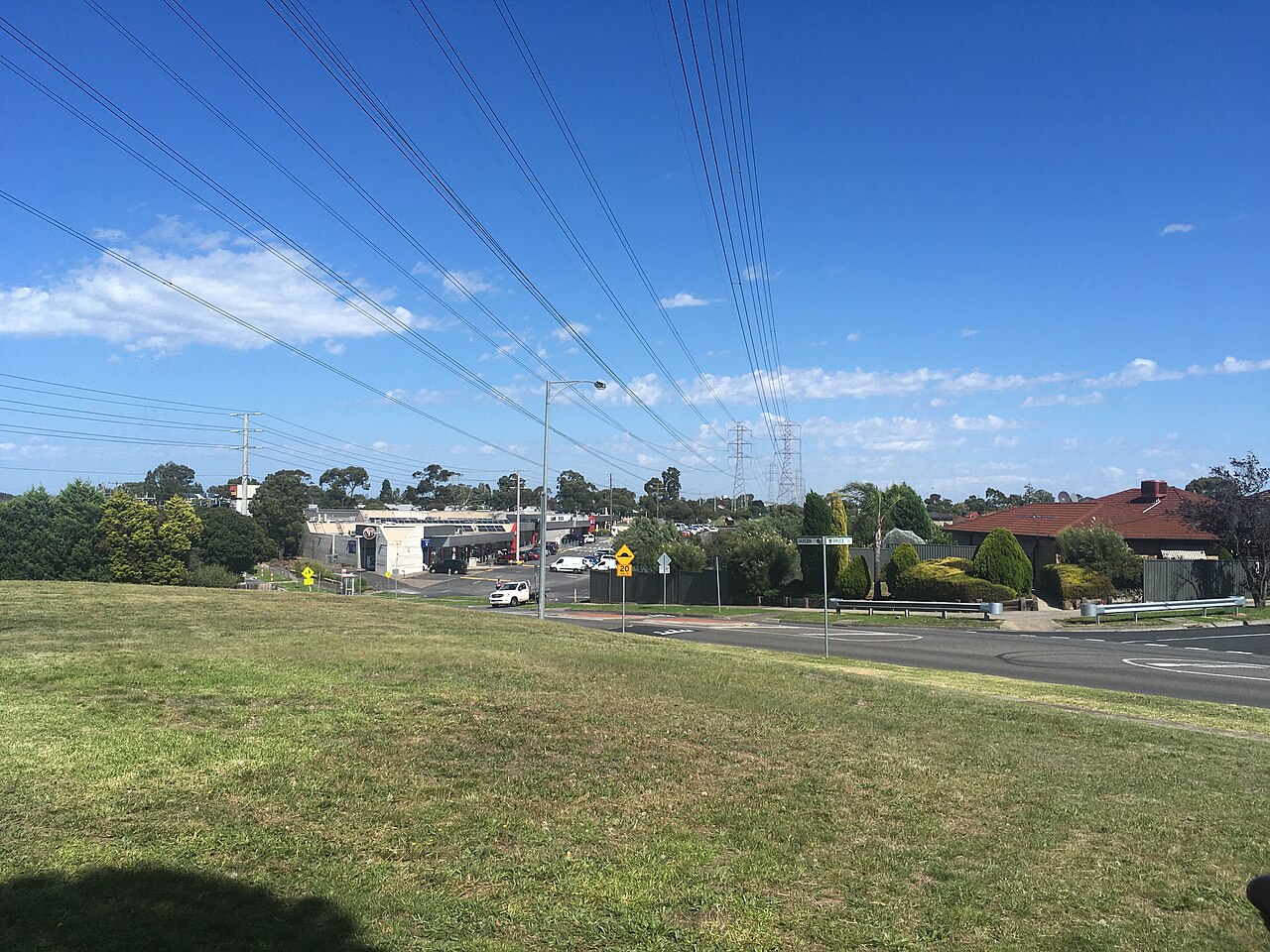 View across open grass towards Lalor Plaza Shopping Centre